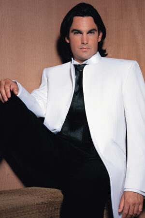 A model poses while wearing the Mirage tuxedo jacket in white.