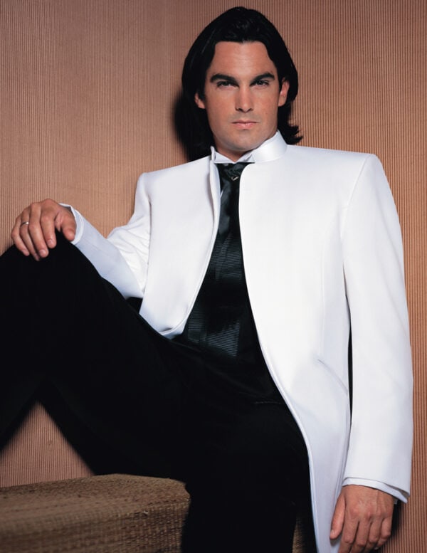 A model poses while wearing the Mirage tuxedo jacket in white.