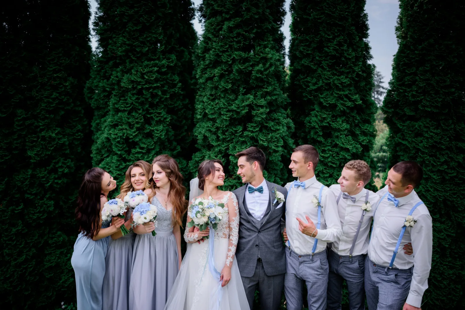 A wedding party of groomsmen and bridesmaids in coordinated wedding attire outdoors